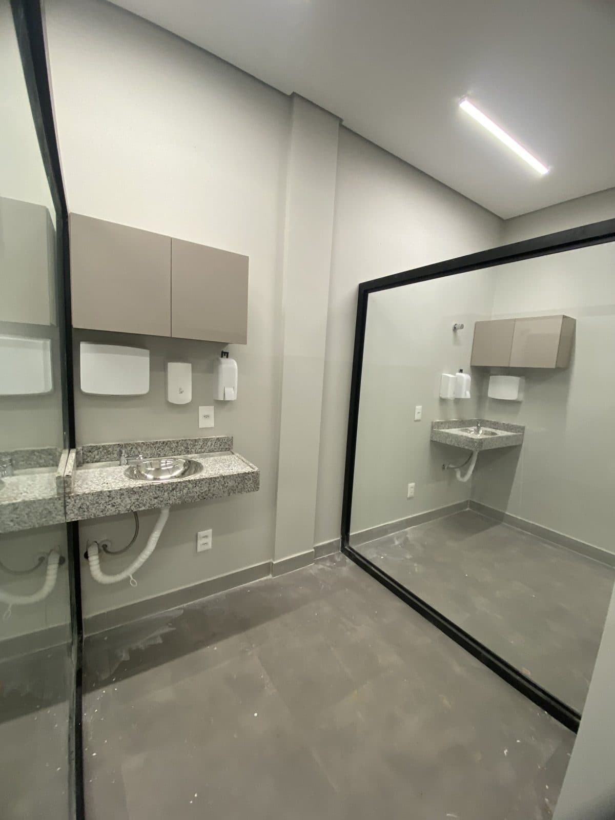 Sala de procedimentos com bancada em granito e divisória de vidro