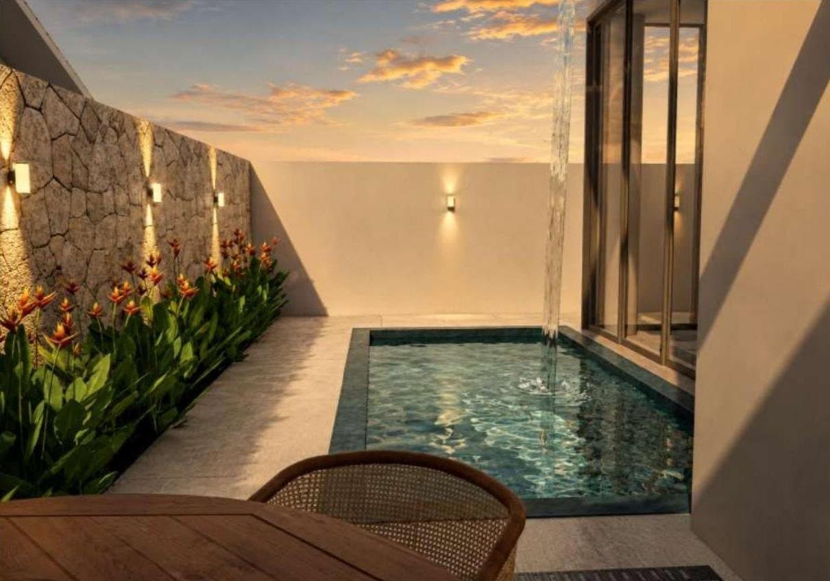 Piscina com cascata e muro de pedra iluminado